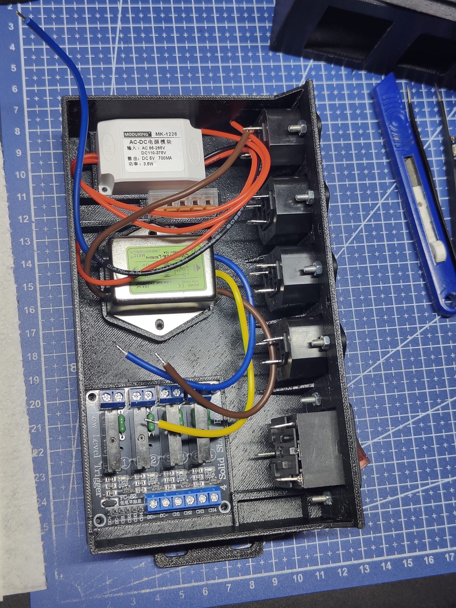 Widok od góry na całą elektronikę — zasilacz, filtr EMI, płytka wyzwalająca i przekaźniki SSR